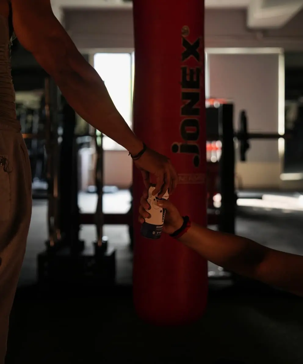 image of a celsius on the go powder being poured into a water cup by a woman